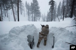 A U.S. Marine covers a machine gun in a trench while preparing for advanced cold-weather training at the Marine Corps Mountain Warfare Training Center on Saturday, Feb. 9, 2019, in Bridgeport, Calif. (AP Photo/Jae C. Hong)