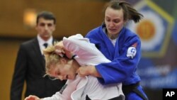 Kayla Harrison of US, in white, fights with Vera Moskalyuk of Russia during the women's under 78 kg category final match at the World Cup Judo tournament in Budapest, Hungary, February 12, 2012.