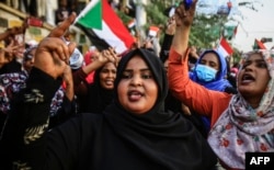 Sudanese women chant slogans during a demonstration demanding a civilian body to lead the transition to democracy, outside the army headquarters in the Sudanese capital Khartoum on April 12, 2019.