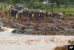 Schoolchildren are stranded across a collapsed bridge in Chimanimani, southeast of Harare, Zimbabwe, March 18, 2019.