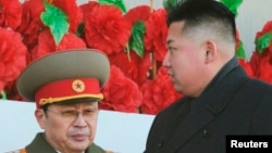 Lãnh đạo Bắc Triều Tiên Kim Jong-un (phải, và người dượng Jang Song-thaek tại một cuộc diễu hành quân sự kỷ niệm ngày sinh của lãnh tụ Kim Jong-Il tại Bình Nhưỡng, ngày 16/2/2012.