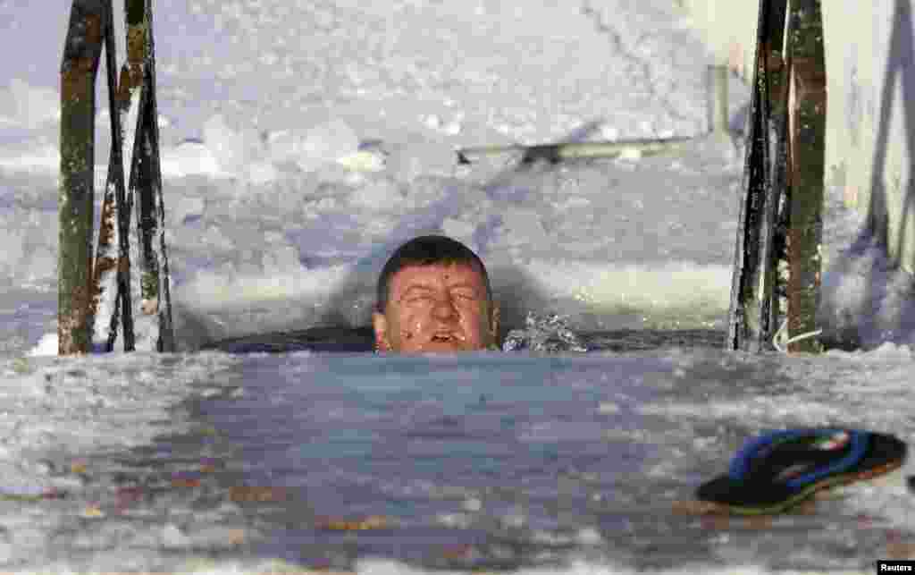 A man takes a dip in icy water in Minsk, Belarus, Jan. 7, 2017.