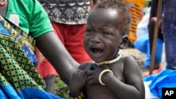 FILE - In this photo taken Dec. 10, 2017, a malnourished baby cries at the feeding center for children in Jiech, Ayod County, South Sudan. 