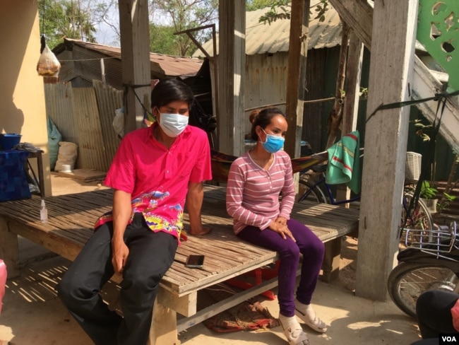 Seang Naroth and Seng Va seated at their family home in Bati district, Takeo province, a day after they completed their 14-day isolation period on April 7, 2020. (Ananth Baliga/VOA Khmer)