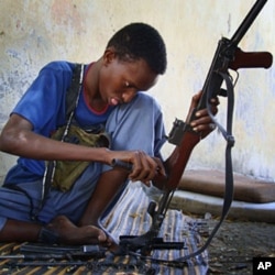Somali fighter loads and cleans AK-47