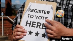 A man holds voter registration forms outside a campaign rally with U.S. Democratic presidential candidate Hillary Clinton in Greensboro, North Carolina, United States September 15, 2016.