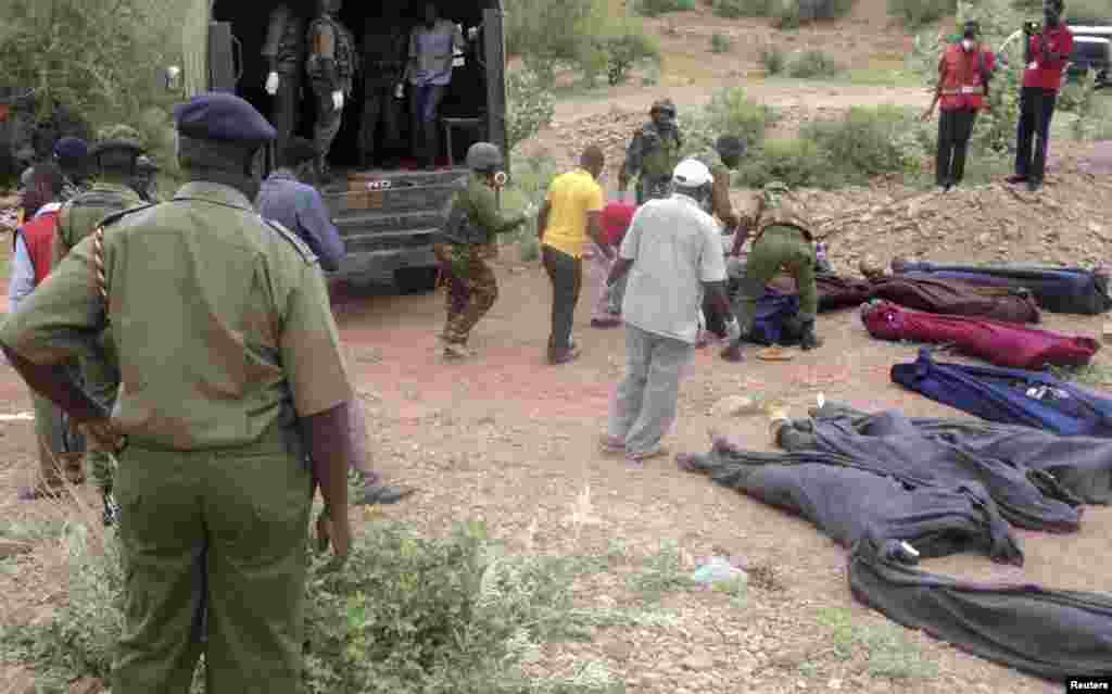 Kenyan military personnel and Red Cross volunteers carry bodies of people killed at a quarry in a village in Korome, outside the border town of Mandera, Dec. 2, 2014.