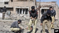 Pakistani police officers collect evidence from the site of a bomb explosion in Peshawar, Pakistan, May 20, 2011