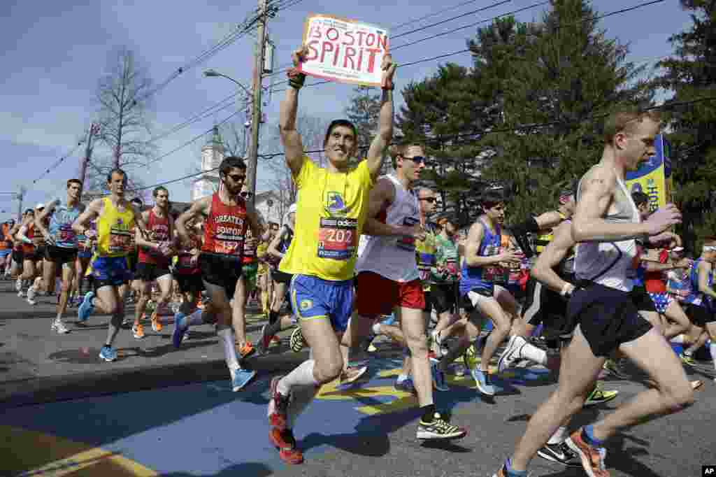 Runners in the first wave of 9,000 cross the start line of the 118th Boston Marathon, in Hopkinton, Mass., April 21, 2014.