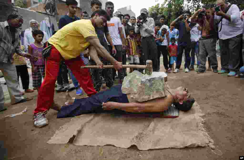 Residents gather to watch as stuntmen display their skills before media in Ahmadabad, India.