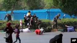 In this photo provided by Mehr News Agency, civilians try to take cover in a shooting attack during a military parade marking the 38th anniversary of Iraq's 1980 invasion of Iran, in the southwestern city of Ahvaz, Iran, Sept. 22, 2018. 