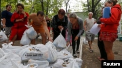 Ukrainian refugees from the Donetsk region receive food as humanitarian aid on the outskirts of the southern coastal town of Mariupol, Sept. 10, 2014.