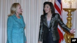 Thailand's Prime Minister Yingluck Shinawatra shows U.S. Secretary of State Hillary Clinton (L) the way during their meeting at the Government House in Bangkok November 16, 2011.
