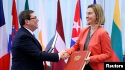 브루노 로드리게스 파릴라 쿠바 외무장관(왼쪽)과 유럽연합 회원국들을 대표하는 페데리카 모게리니 유럽연합 외교담당 고위대표가 12일 벨기에 브뤼셀에서 관계 정상화 협정을 체결한 후 악수하고 있다.