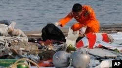 A member of Indonesian Search and Rescue Agency (BASARNAS) inspects debris believed to be from Lion Air passenger jet that crashed off Java Island at Tanjung Priok Port in Jakarta, Indonesia, Oct. 29, 2018. 
