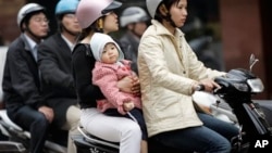 People ride motorbikes in Hanoi. Urban planners hope a new subways system will reduce congestion, improve safety and cut pollution.