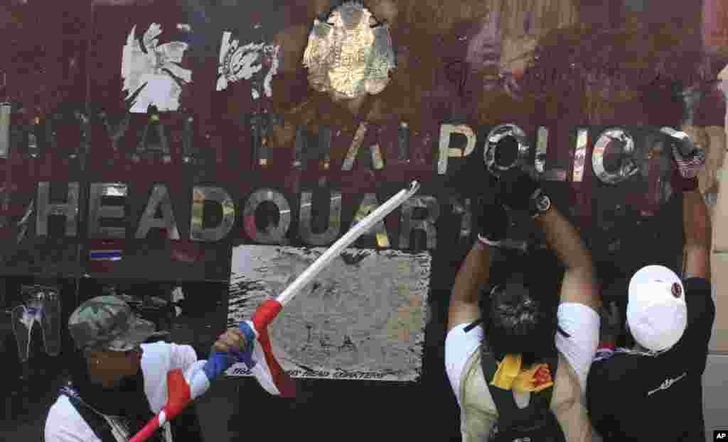 Anti-government protesters remove letters from the exterior of the Royal Thai police headquarters during a rally in Bangkok, Jan. 22, 2014.