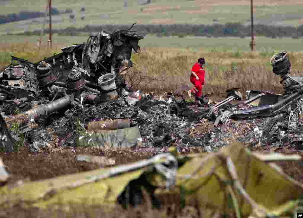 A paramedic walks in charred debris at the crash site of Malaysia Airlines Flight 17 near the village of Hrabove, eastern Ukraine, July 20, 2014.