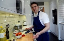 on Watts, demonstrates his cooking skills for the Associated Press by making a prawn linguini at a friends kitchen in Codicote, Welwyn, England, Thursday, April 15, 2021.