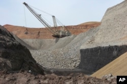 FILE - A dragline excavator moves rocks above a coal seam at the Spring Creek Mine in Decker, Mont., April 4, 2013.