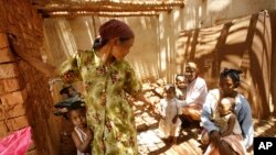 Des femmes et des enfants malgaches attendent dans une clinique improvisée à Antanetikely, Madagascar, le 23 octobre 2007.