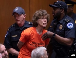 A protester is removed by Capitol Police officers as she shouts at Gina Haspel, President Donald Trump's pick to lead the Central Intelligence Agency, at her confirmation hearing before the Senate Intelligence Committee, on Capitol Hill in Washington, May 9, 2018.