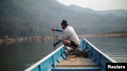 A local villager drive a boat where the future site of the Luang Prabang dam will be on the Mekong River, outskirt of Luang Prabang province, Laos, February 5, 2020. (REUTERS/Panu Wongcha-um)