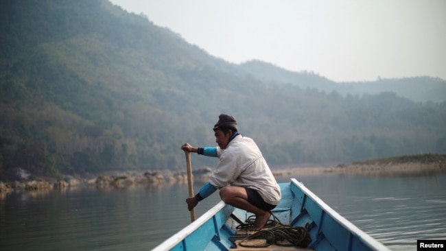A local villager drive a boat where the future site of the Luang Prabang dam will be on the Mekong River, outskirt of Luang Prabang province, Laos, February 5, 2020