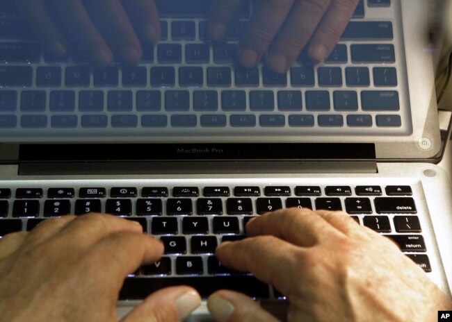 FILE - In this Feb. 27, 2013, file photo illustration, hands type on a computer keyboard in Los Angeles.