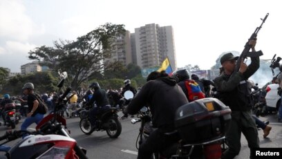 Soldiers and people react to the sound of gunfire near the Generalisimo Francisco de Miranda Airbase "La Carlota" in Caracas, Venezuela, April 30, 2019.
