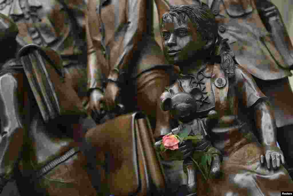 A rose is placed a the Kindertransport memorial outside of Liverpool Street Station in London. The statue is dedicated to remembering the effort by the U.K. prior to the outbreak of the World War II in taking in nearly 10,000 predominantly Jewish children. PM David Cameron says Britain will welcome &quot;thousands more&quot; Syrian refugees, after an outpouring of emotion over the image of a Syrian toddler lying dead on a Turkish beach put him under pressure to act.
