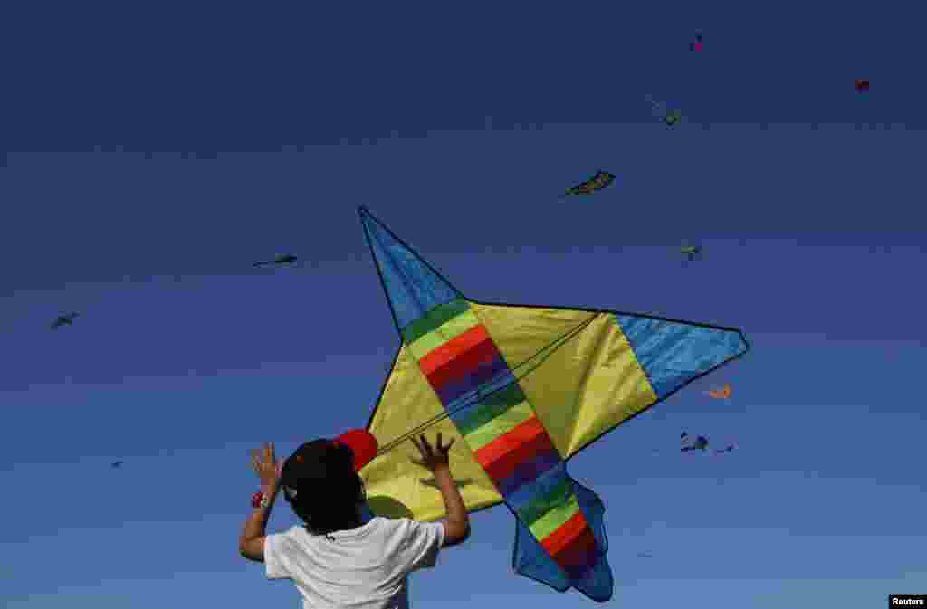A boy releases a kite during the annual Singapore Kite Festival in the central business district area of Marina Bay in Singapore.