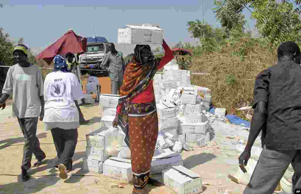 남수단 폭력사태로 주민들이 유엔 대피소에서 임시 거주 중인 가운데, 23일 한 여성이 긴급구호식량을 머리에 이고 가고 있다. 