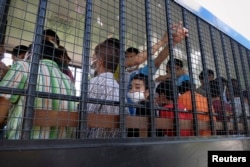 FILE - Suspected Uighurs are transported back to a detention facility in the town of Songkhla in southern Thailand after visiting women and children at a separate shelter, March 26, 2014.