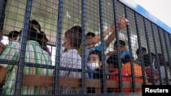 Suspected Uighurs are transported back to a detention facility in the town of Songkhla in southern Thailand after visiting women and children at a separate shelter, March 26, 2014.