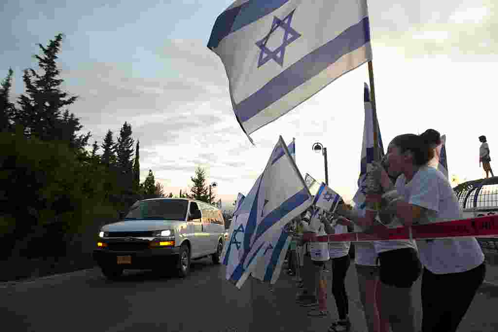 Los residentes de Mitzpe Hila, en el norte de Israel, hacen ondear las banderas israelíes para saludar la llegada de Gilad Shalit.