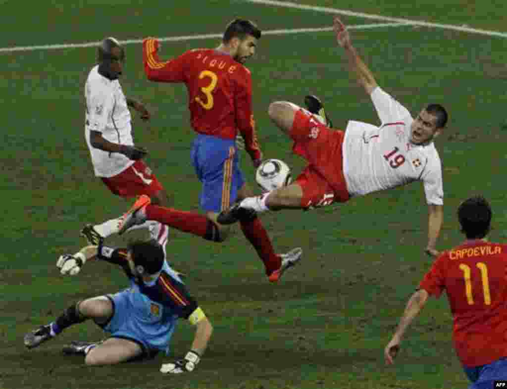 Швейцарец Эрен Дердийок (в центре), испанец Херард Пике (второй слева вверху) вратарь команды Испании Икер Касильяс (внизу слева), борются за мяч во время матча между Испанией и Швейцарией на стадионе в Дурбане, Южная Африка. Среда, 16 июня 2010. (Фото АП