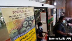 A sign raising awareness for the MERS virus is posted on a door at the building where a 75-year-old man is being quarantined for MERS (Middle East Respiratory Syndrome) along with three family members at the Bamrasnaradura Infectious Diseases Institute in Nonthaburi, Thailand, Friday, June 19, 2015. Thailand confirmed on Thursday its first known case of the deadly MERS virus, after killing a number of people in South Korea over recent weeks. Writing in Thai says, "If you have traveled from Saudi Arabia, United Arab Emirates, Qatar, Iran, or South Korea and have respiratory trouble please seek attention." (AP Photo/Sakchai Lalit)