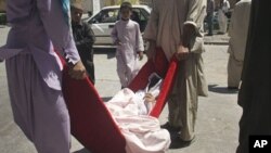 Afghans carry a female victim of a roadside bomb in to a hospital in Herat, west of Kabul, Afghanistan, August 18, 2011