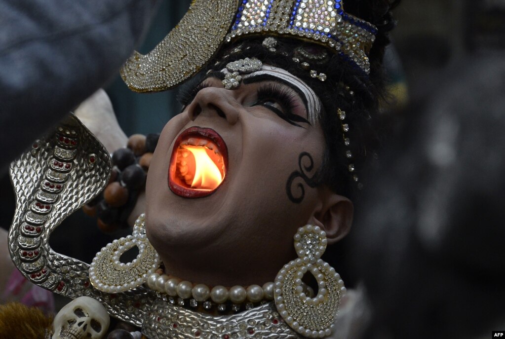 인도 잘란드하르에서 열린 마하시브라트리 축제에서 시바 신으로 분장한 남성이 입 안에 초를 켰다.