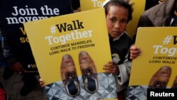 A child holds a placard during a walk to commemorate what would have been Nelson Mandela's 99th birthday in Cape Town, South Africa, July 18, 2017. 