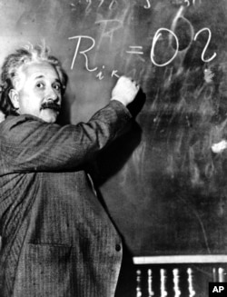 Albert Einstein writes out an equation for the density of the Milky Way on the blackboard at the Carnegie Institute, Mt. Wilson Observatory headquarters in Pasadena, Calif., on Jan. 14, 1931.