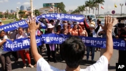 A leader, foreground, of Cambodian activists controls the group to pay respects in front of Royal Palace during a march toward the National Assembly, in Phnom Penh, file photo. 