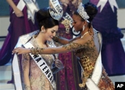 Miss Universo, Leila Lopes (dir.) coloca o manto de vencedora sobre o ombros da nova Miss Indonesia 2011 Maria Selena