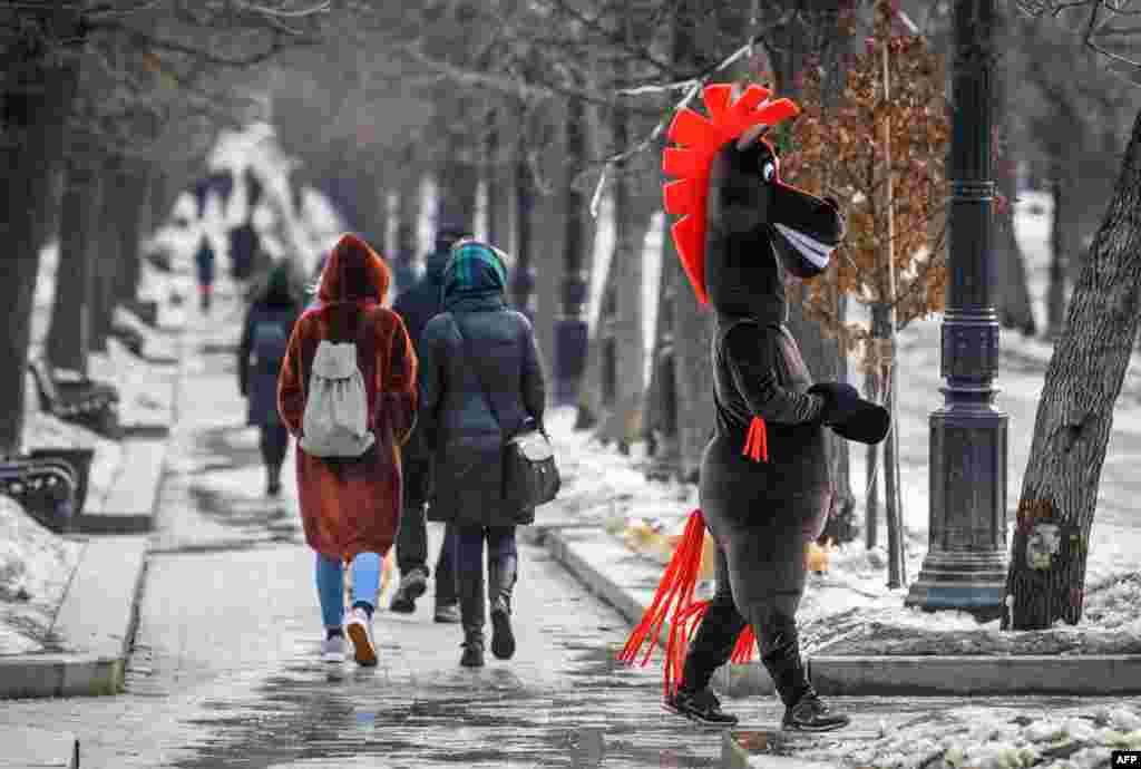 A man dressed as a horse entertains pedestrians on a boulevard in Central Moscow, Russia.