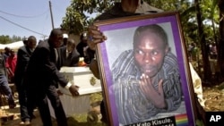 A member of the Ugandan gay community carries a picture of murdered gay activist David Kato during his funeral near Mataba, January 28, 2011.