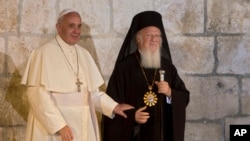 FILE - Pope Francis stands with Ecumenical Patriarch Bartholomew I as they meet outside the Church of the Holy Sepulchre, in Jerusalem's Old City, May 25, 2014. 