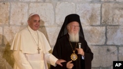 FILE - Pope Francis stands with Ecumenical Patriarch Bartholomew I as they meet outside the Church of the Holy Sepulchre, in Jerusalem's Old City, May 25, 2014.