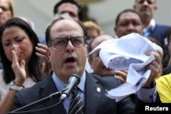 Julio Borges, president of Venezuela's National Assembly, waves a torn copy of the Supreme Court's decision at a news conference in Caracas, Venezuela, March 30, 2017.