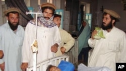 Pakistani tribesmen gather around an injured boy at a hospital in Miranshah, the main town in North Waziristan on following a US drone attack, 22 May 2010